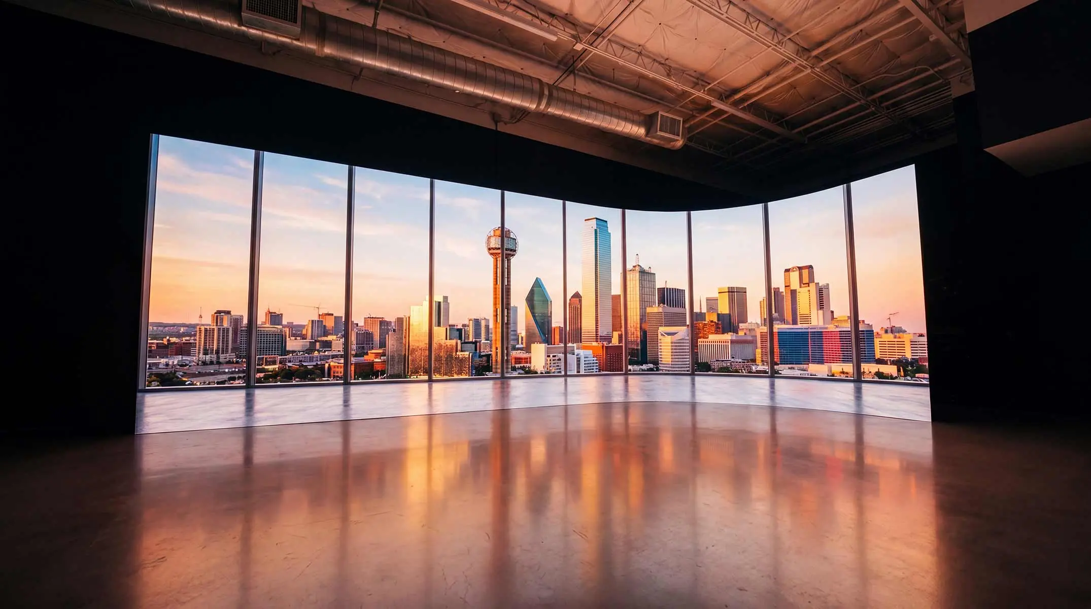 The Big Screen Stage, a curved LED wall displaying a Dallas skyline, with an empty stage floor